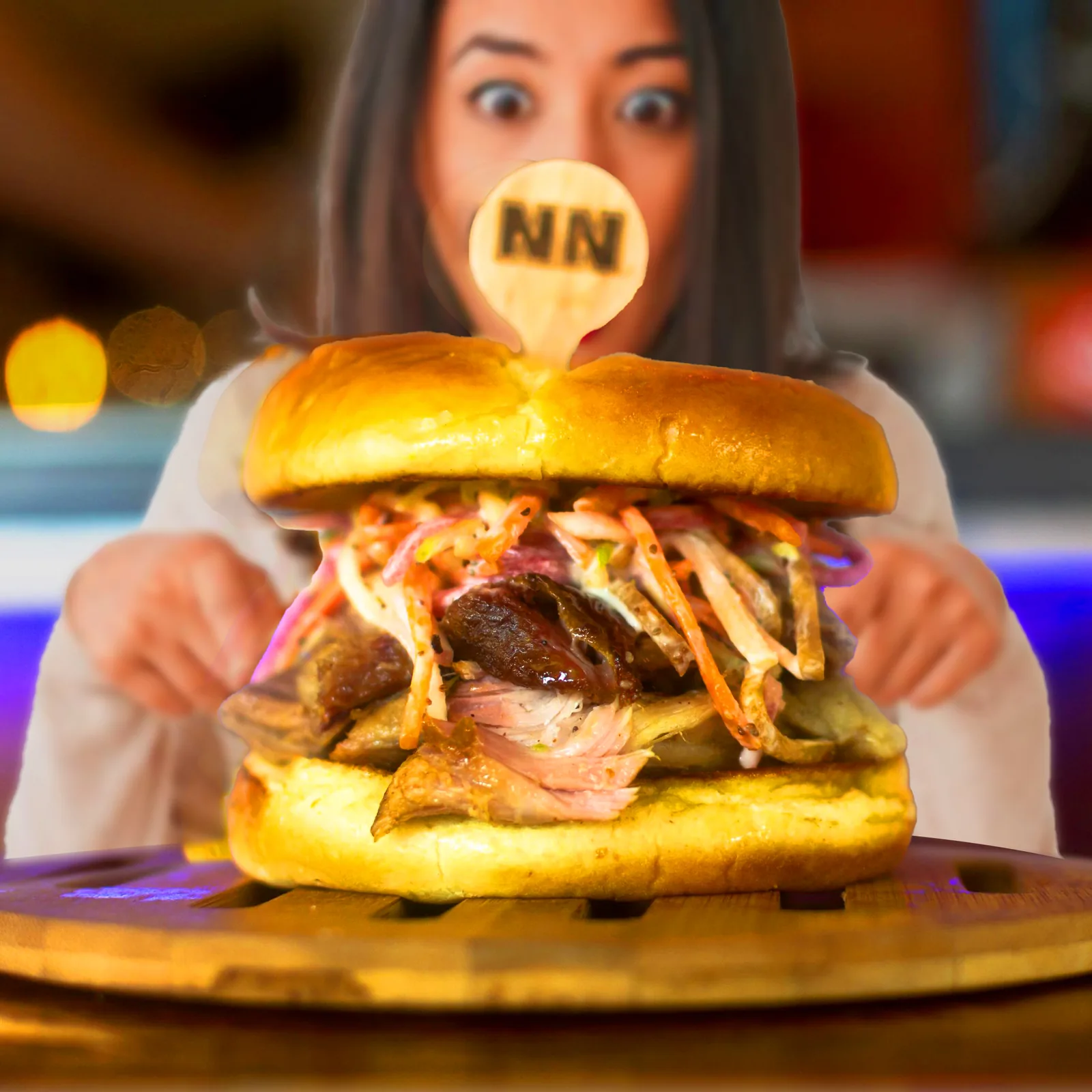 Guest marveling at a towering NN Burger specialty sandwich